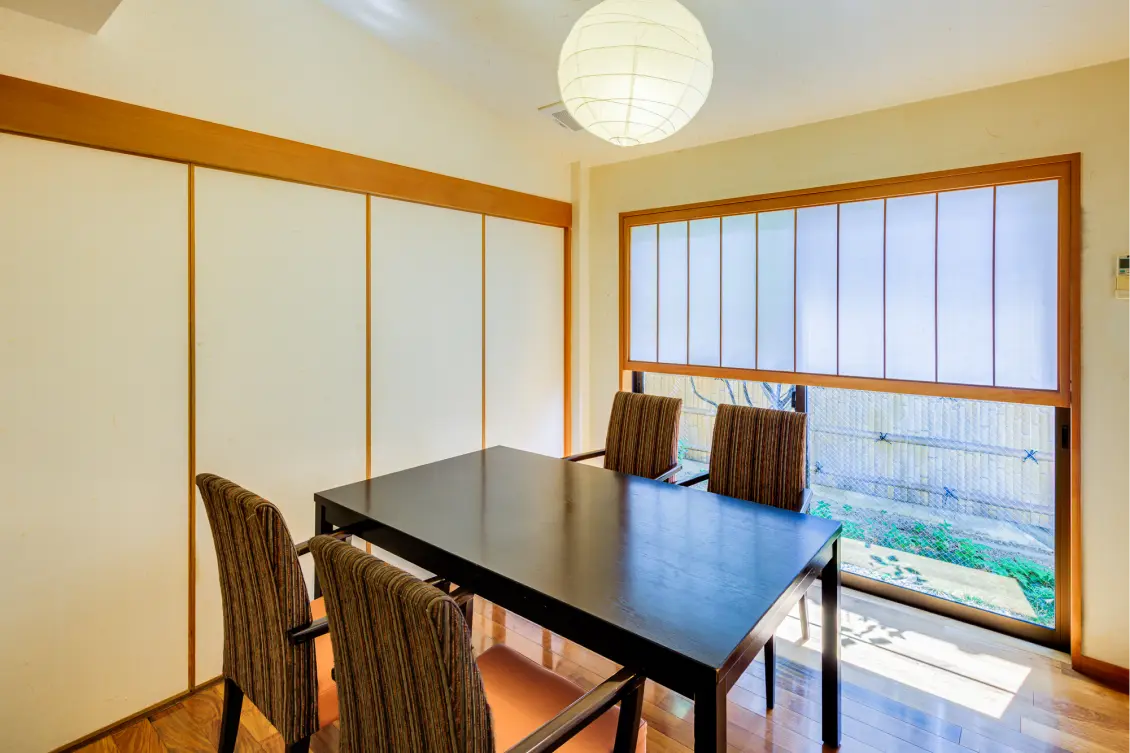 テーブルと椅子が置かれた個室ダイニング。障子風の引き戸と窓が和の雰囲気を醸し出す。