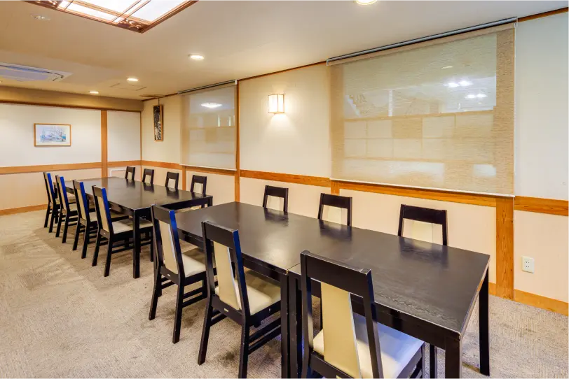 畳にテーブルと椅子が並んだ宴会場。団体客向けの食事スペース。