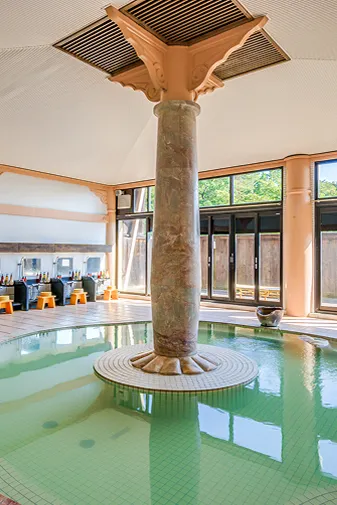 広々とした大浴場、中央に柱のある湯船