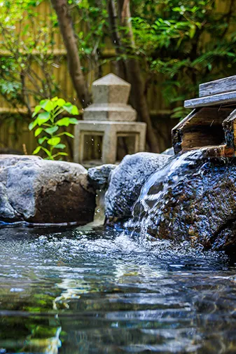 日本庭園の石灯籠と池、緑に囲まれた落ち着いた景色