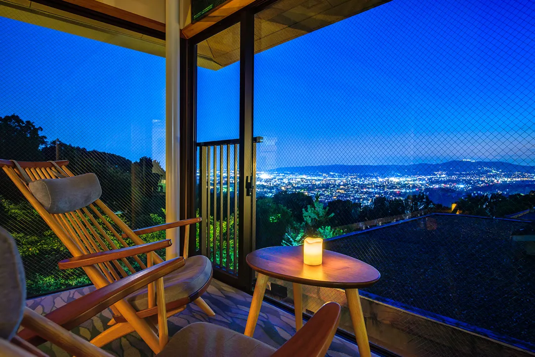 バルコニーのチェアから夜景を眺める風景、夜空と街の灯り