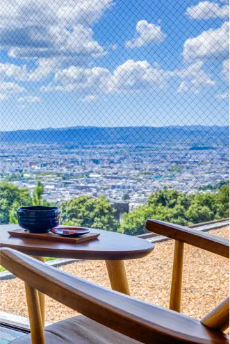 陶器の茶碗が置かれたテーブルと椅子がある窓際の席。