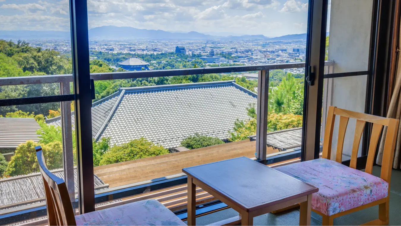 伝統的な屋根と遠くに広がる街並みが見える展望付きのバルコニー。