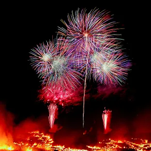 打ち上げ花火が夜空を華やかに彩る、お祭りの夜景。