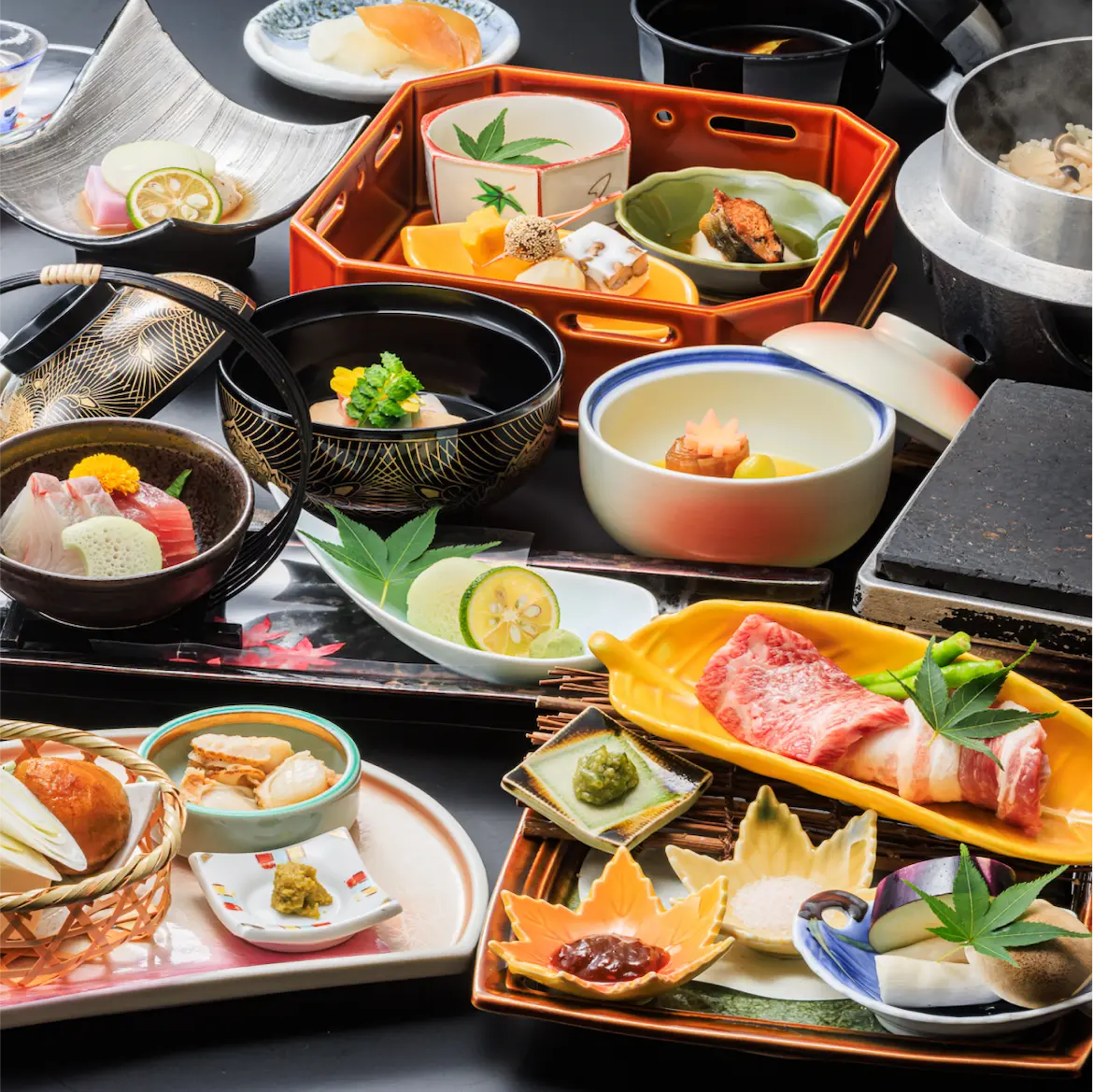 季節の食材がふんだんに使われた、色とりどりの会席料理が並べられた写真。