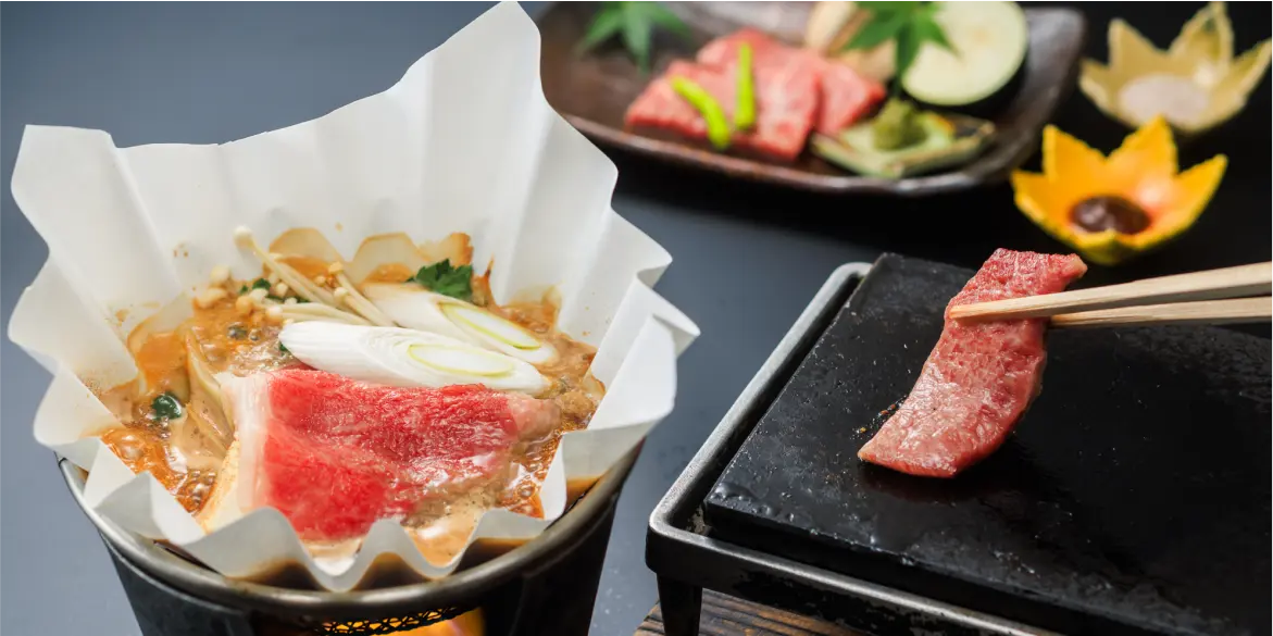 一人用の鍋と、石のプレートで焼いて食べる肉が写っている写真。