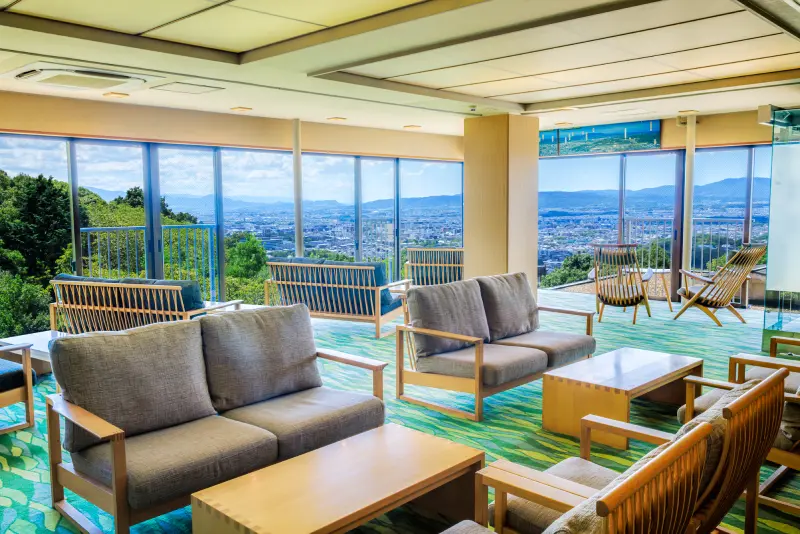 大きな窓から奈良の街並みを一望できる、ソファや椅子が複数配置された広々としたロビー。