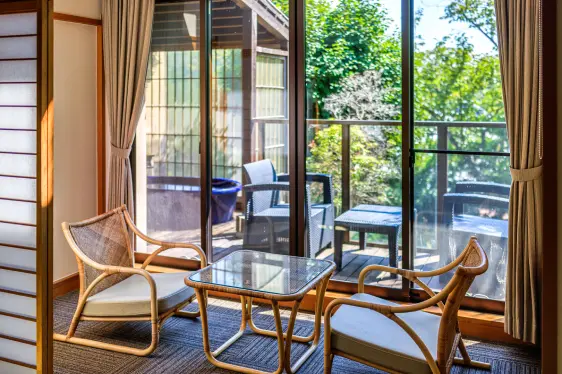 客室の窓際に置かれた、ラタン製の椅子2脚と小さなガラスのテーブル。