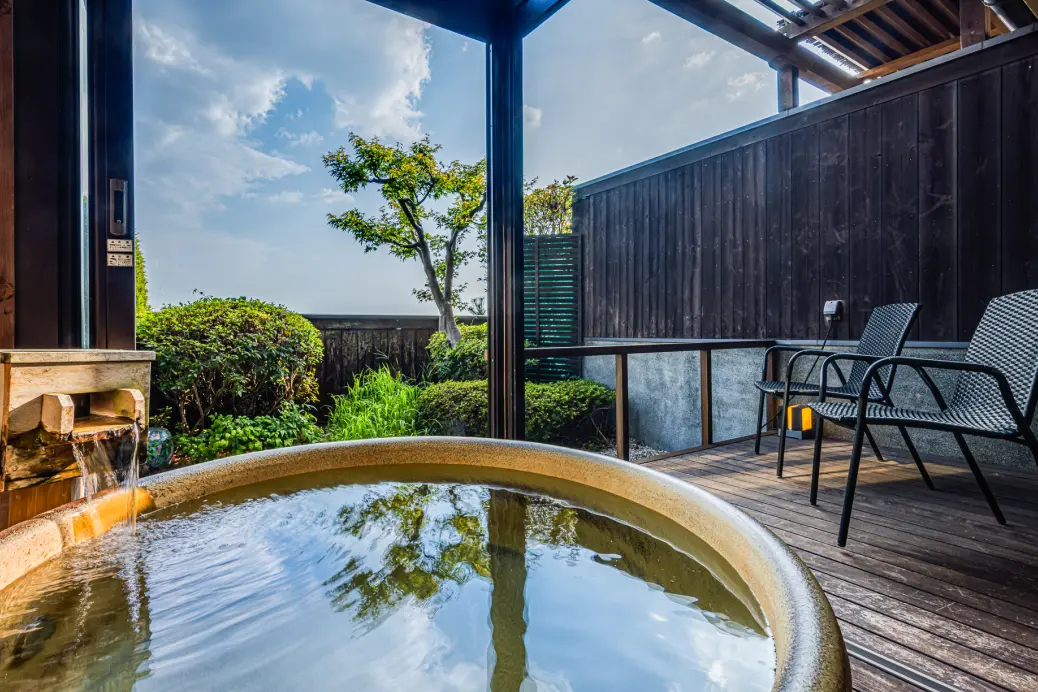 露天風呂付きの客室のテラスに設置された、大きな丸い石の露天風呂。