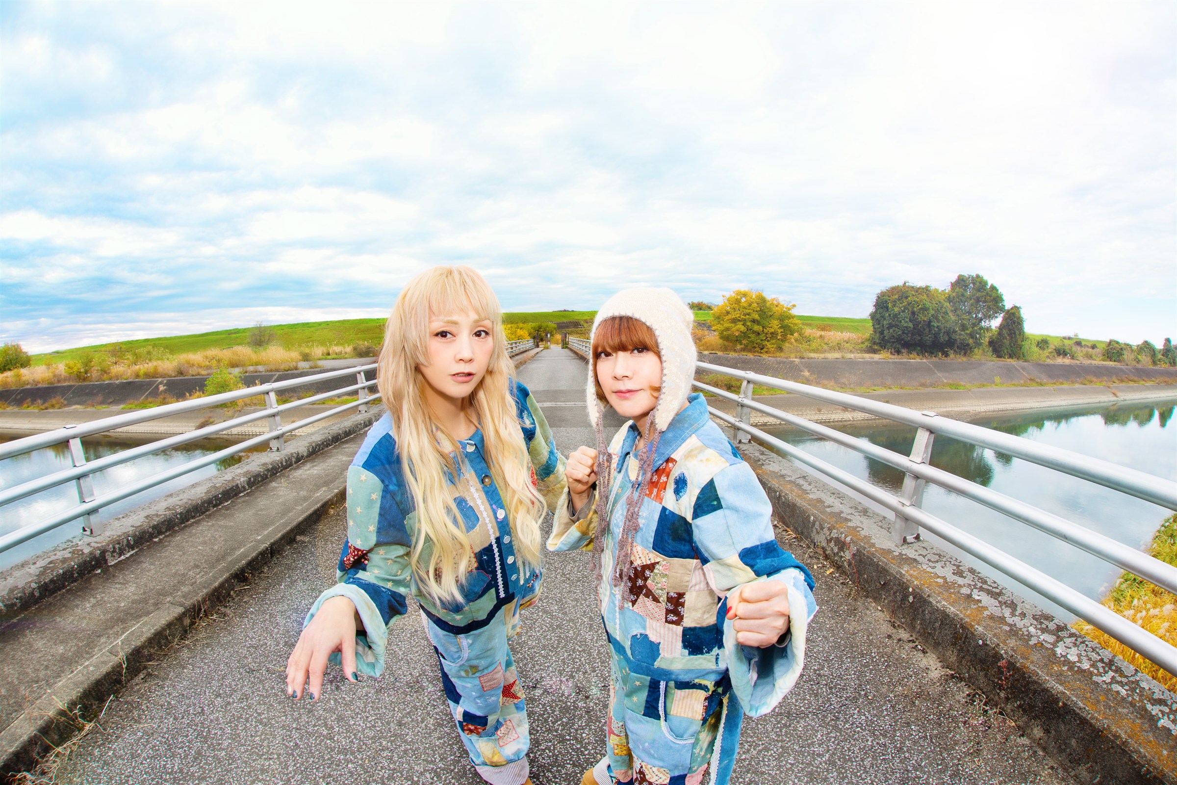青空の下、橋の上でカメラに向かうPUFFYの大貫亜美と吉村由美